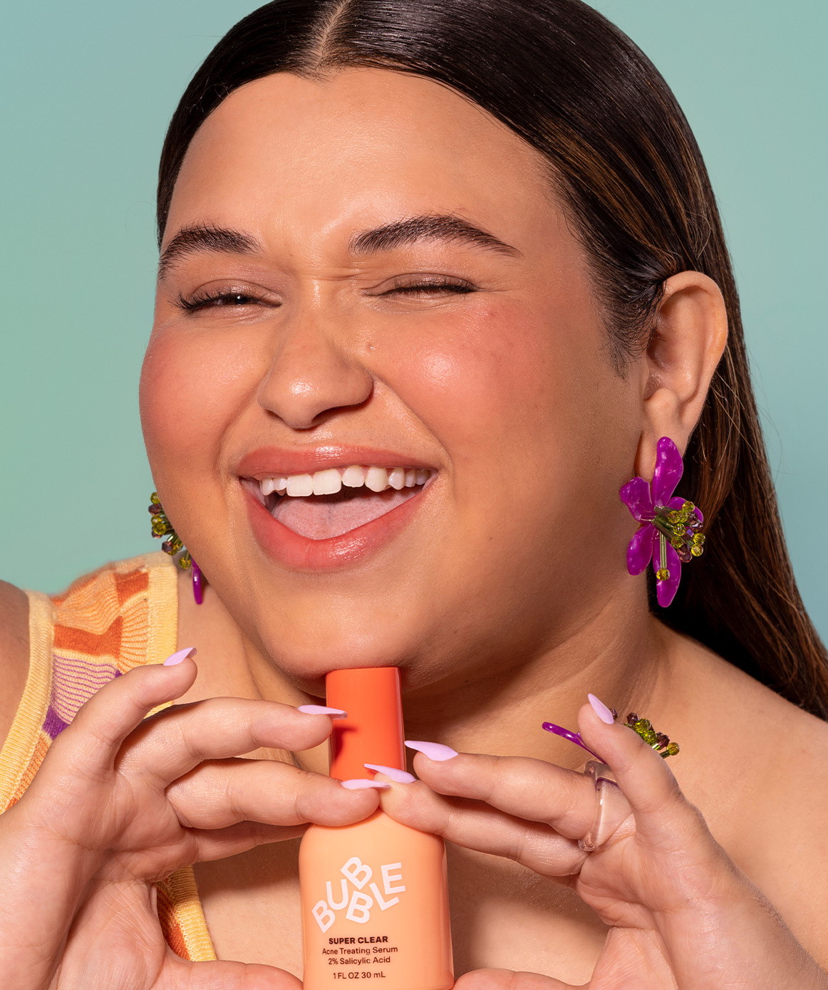 Woman holding acne treating serum part of a bundle of products for acne. One serum, one moisturizer, one gel cleanser, one toner.