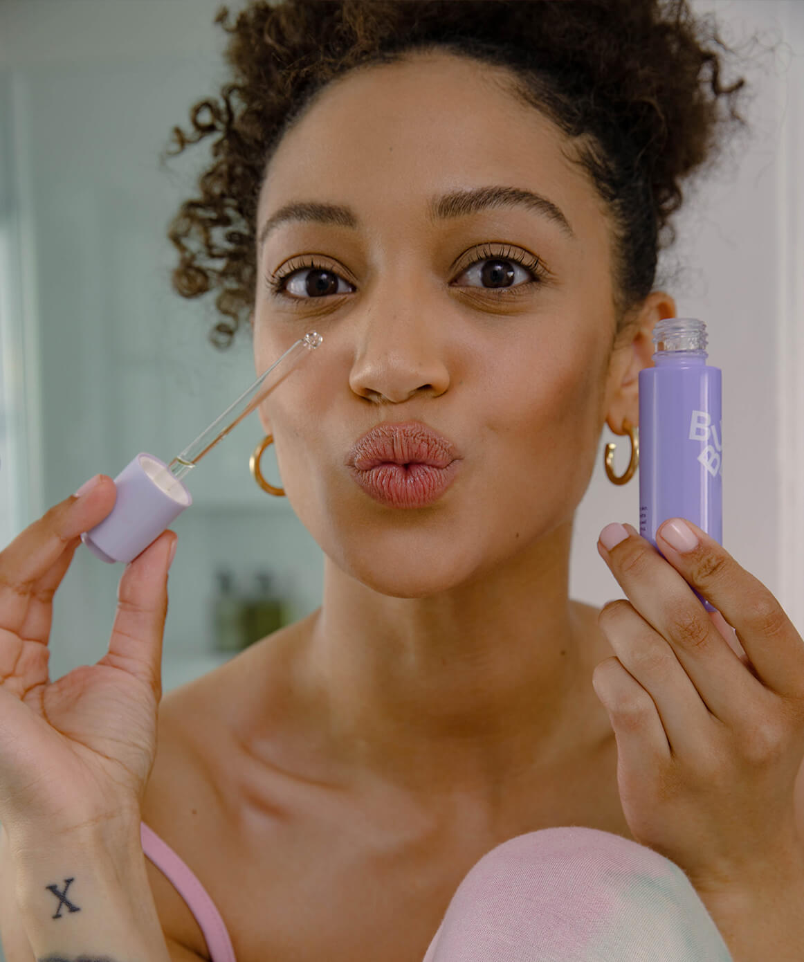 Woman applying face oil.